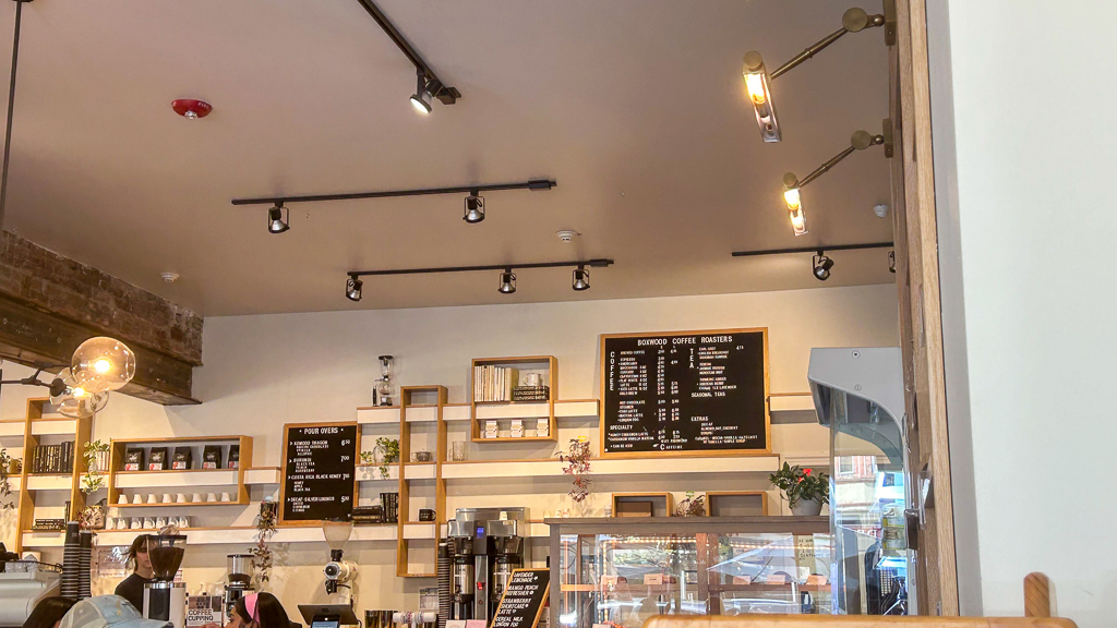 Interior of Boxwood café, showcasing a minimalist coffee bar with stylish shelving against a modern, well-lit backdrop.